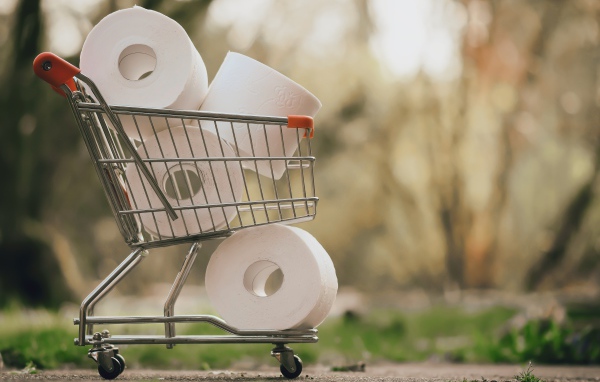 Много рулонов туалетной бумаги в железной тележке 