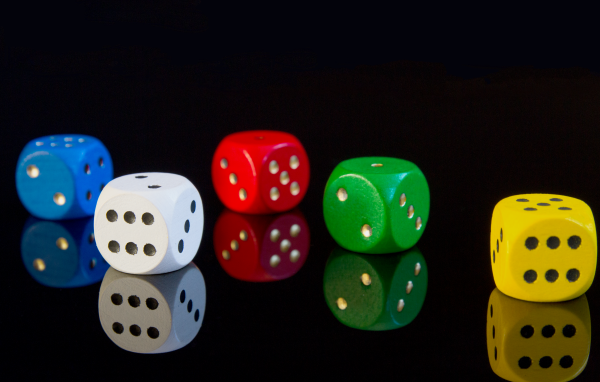 Разноцветные игральные кубики на черном фоне