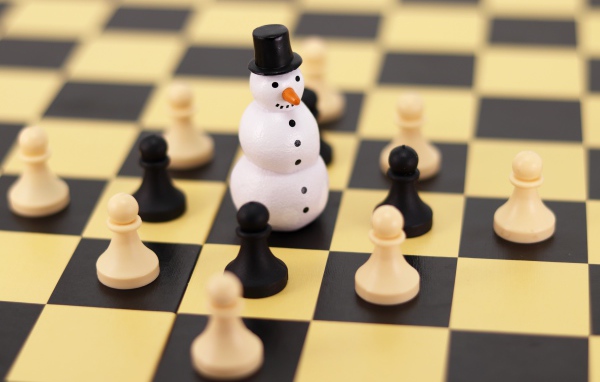 Фигурка снеговика на шахматной доске