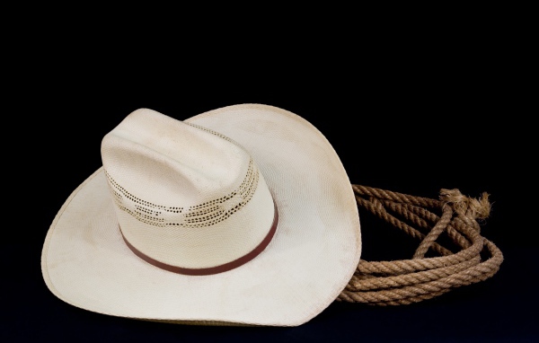 Белая ковбойская шляпа с лассо на черном фоне