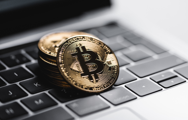 Монеты биткоин лежат на клавиатуре ноутбука 