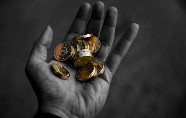 Много монет в руке у мужчины