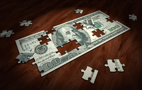 Пазл из купюры сто долларов на столе 