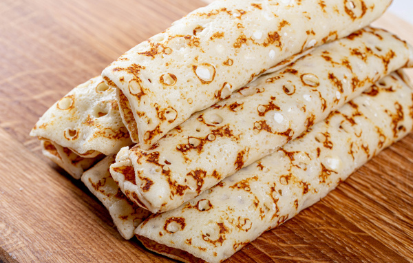 Аппетитные блины на деревянном столе 