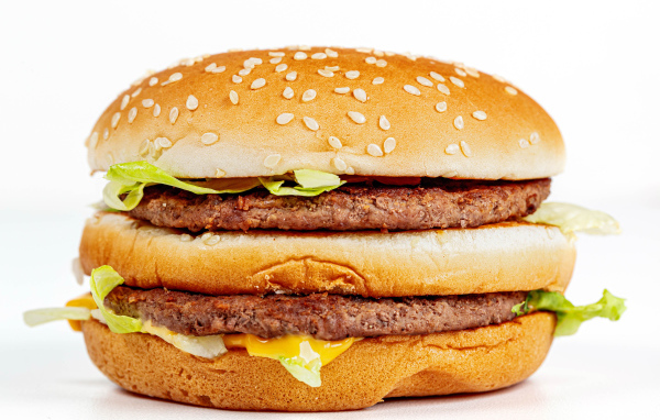 Большой аппетитный гамбургер на белом фоне