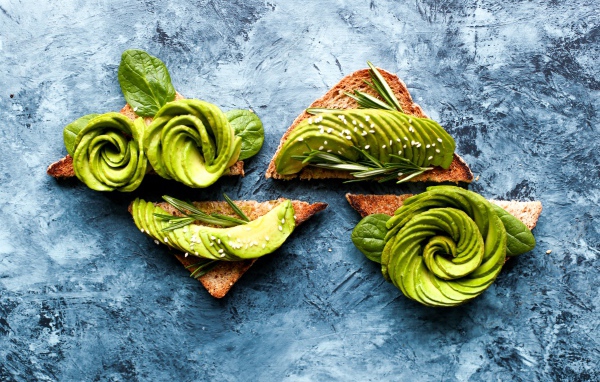 Bread with avocado and basil on the table