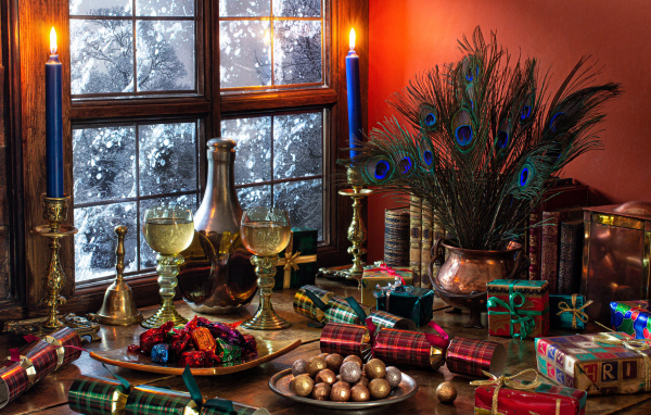 Конфеты,  подарки и старинные предметы на столе у окна