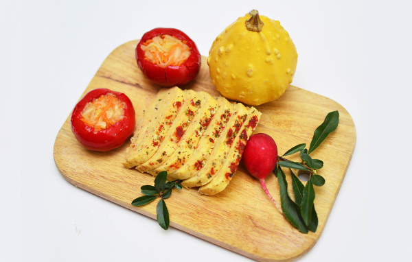 Сыр с овощами на разделочной доске на белом фоне