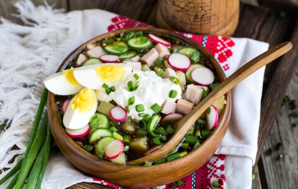 Холодная окрошка в деревянной миске на столе 