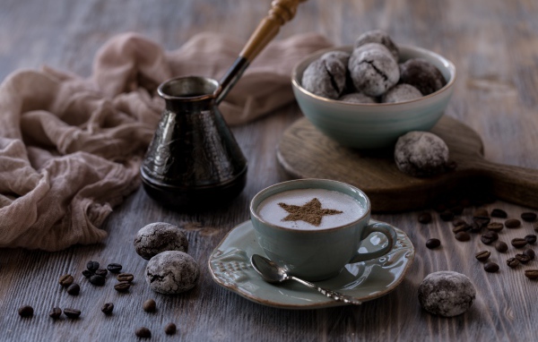 Чашка кофе на столе с пряниками и зернами