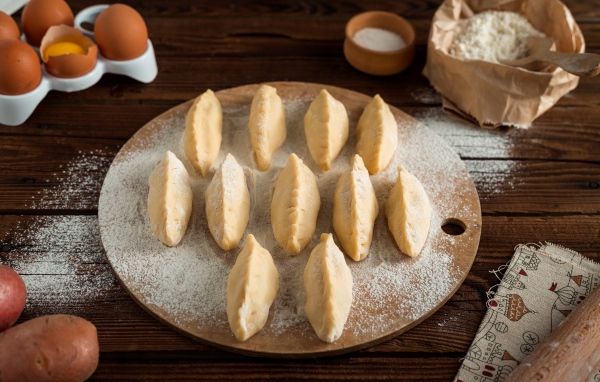 Вареники с картошкой на доске с мукой