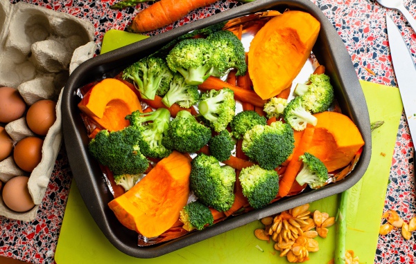 Свежие брокколи, морковь и тыква на противне 