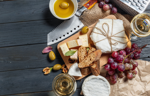 Виноград на столе с сыром, хлебом и оливками
