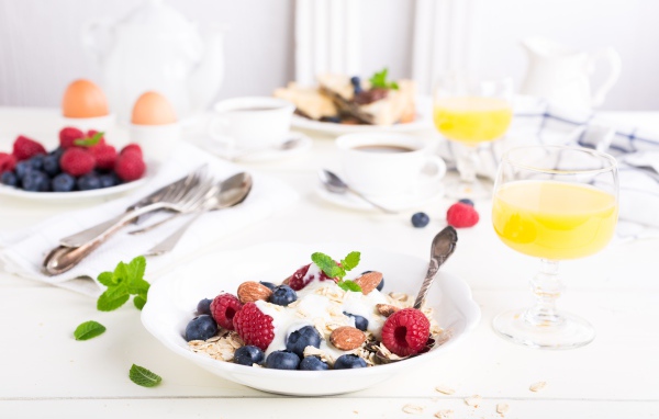 Oatmeal on a table with blueberries, raspberries and nuts