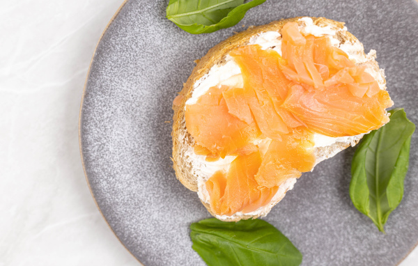 Бутерброд с сыром, красной рыбой и листьями базилика