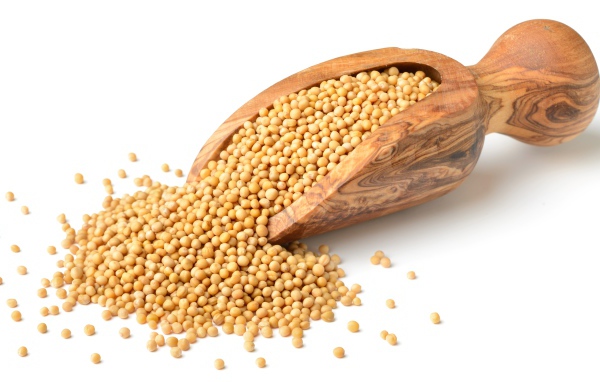 Мелкий горох в деревянном совке на белом фоне