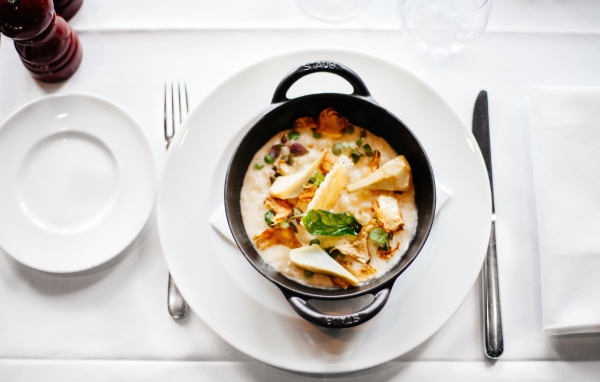 Суп в миске стоит на белой тарелке 