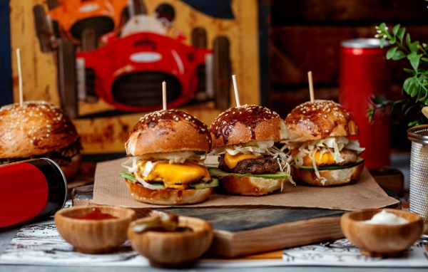 Вкусные гамбургеры на столе с соусом и кока колой 