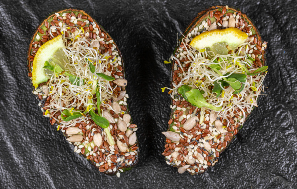 Половинки авокадо с проросшими зернами на столе