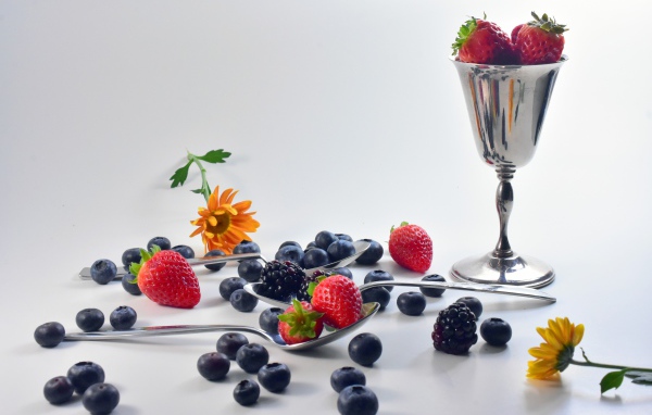 Ежевика, черника и клубника на столе с ложками