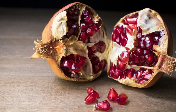 Разломанный красный гранат на столе 