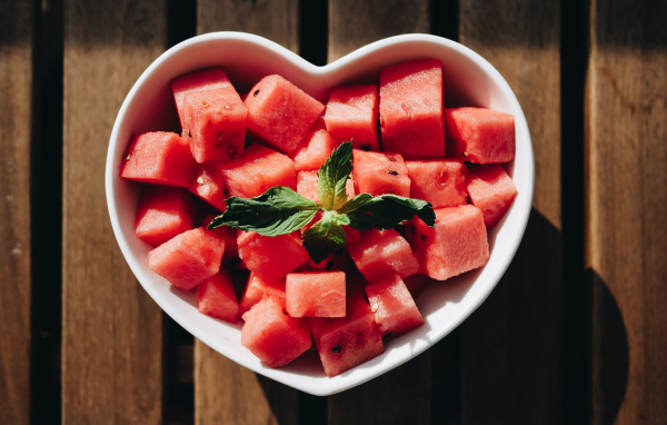 Нарезанный кубиками арбуз в белой тарелке в форме сердца