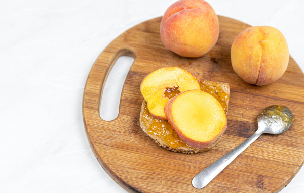 Свежие персики на столе с хлебом 