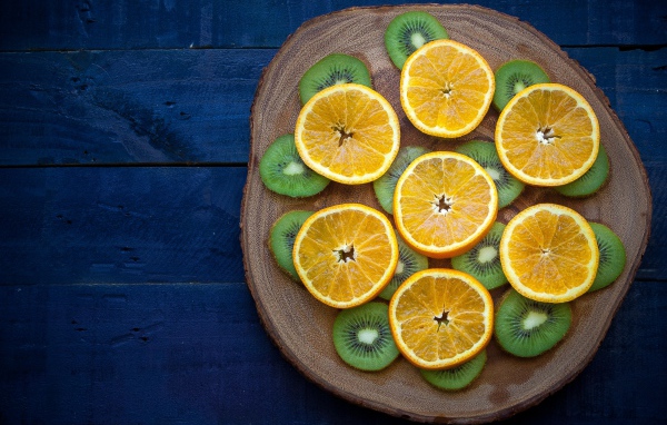 Kiwi slices with oranges on a chalkboard