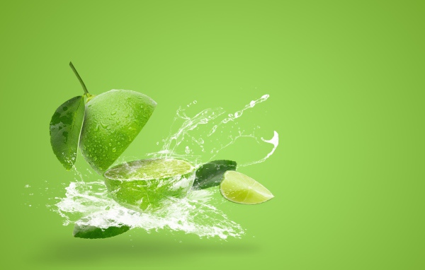 Лайм в брызгах воды на зеленом фоне
