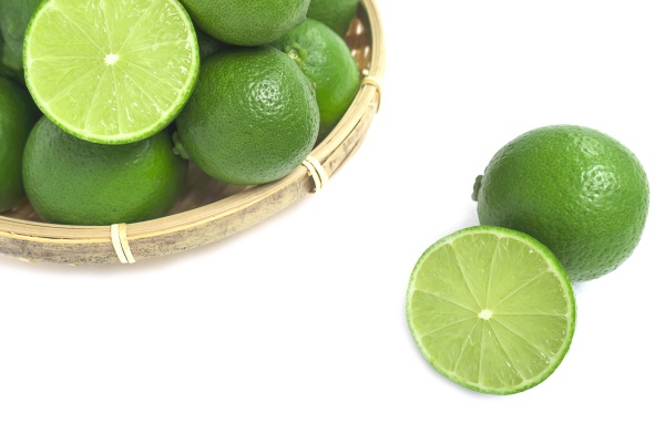Кислые плоды зеленого лайма на белом столе