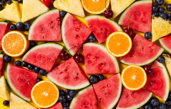 Вкусные свежие фрукты на желтом столе 