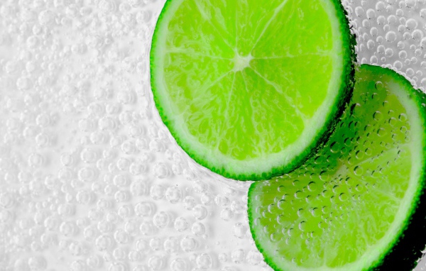 Два куска лайма в пузырях в воде 
