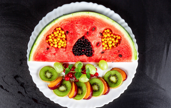 Арбуз на тарелке с ягодами 