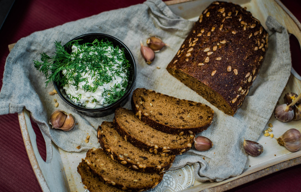 Свежий хлеб с зернами на столе с соусом и чесноком