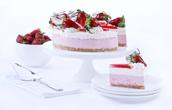 Аппетитный праздничный торт с клубникой на столе 