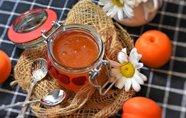 Абрикосовый джем на столе с ромашками