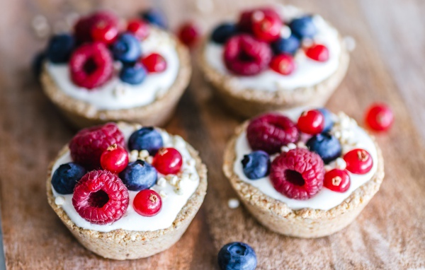 Пирожные с кремом и ягодами на столе крупным планом