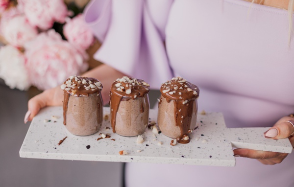 Шоколадный десерт в банках в руках у девушки
