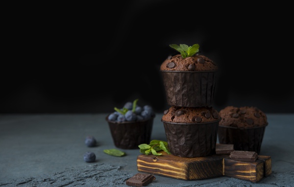 Кексы с шоколадом на столе с ягодами черники на столе 