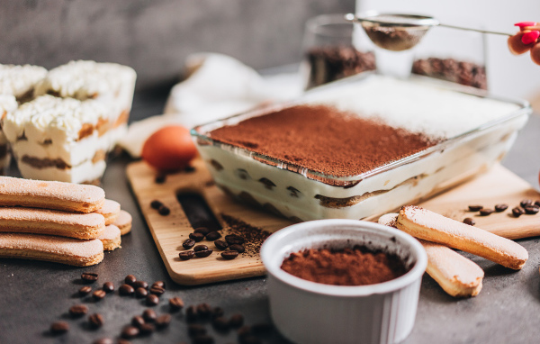 Десерт тирамису на столе с какао 