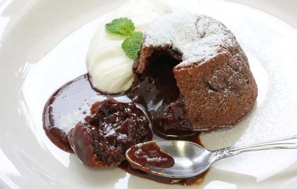 Десерт с шоколадом и сливками на белой тарелке 