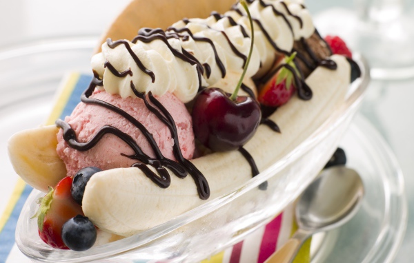 Шарики мороженого на тарелке с бананами и черешней 