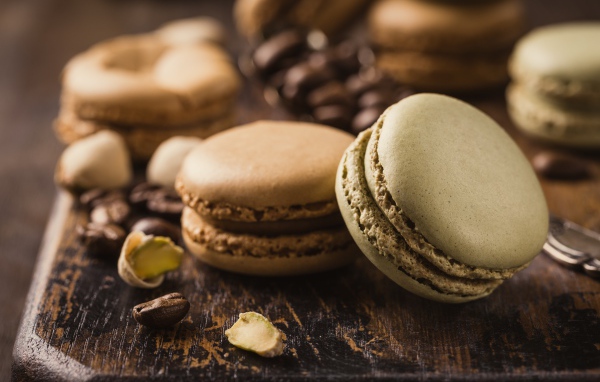 Десерт макарун на столе с кофейными зернами