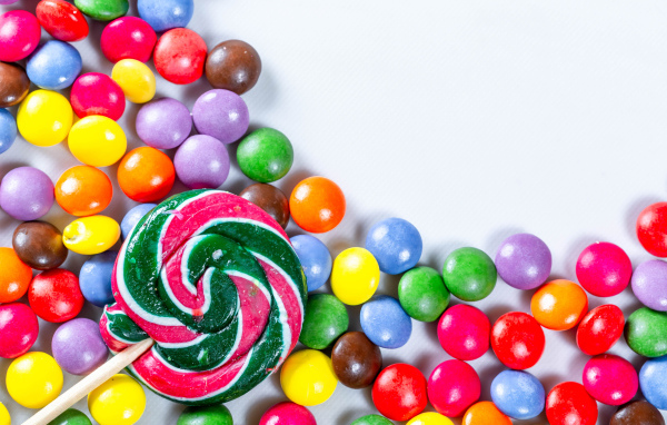 Разноцветные конфеты в глазури и карамель на белом фоне 