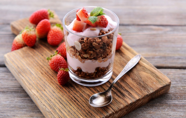 Овсяные хлопья в стакане с йогуртом и ягодами клубники