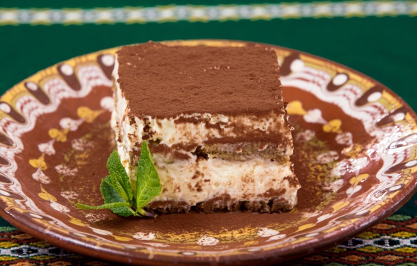 Кусок торта тирамису на тарелке 