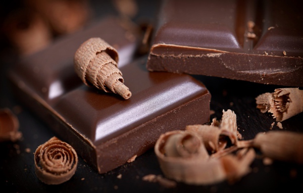 Куски шоколада и стружка на столе крупным планом