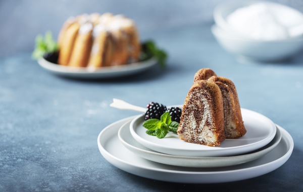 Кусочки кекса на тарелке с ягодами ежевики