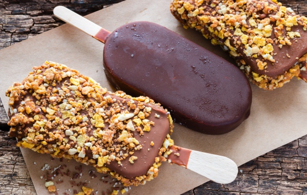 Вкусное холодное мороженое в шоколаде на столе 