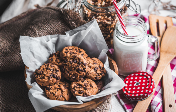Вкусное печенье с шоколадом на столе с молоком 